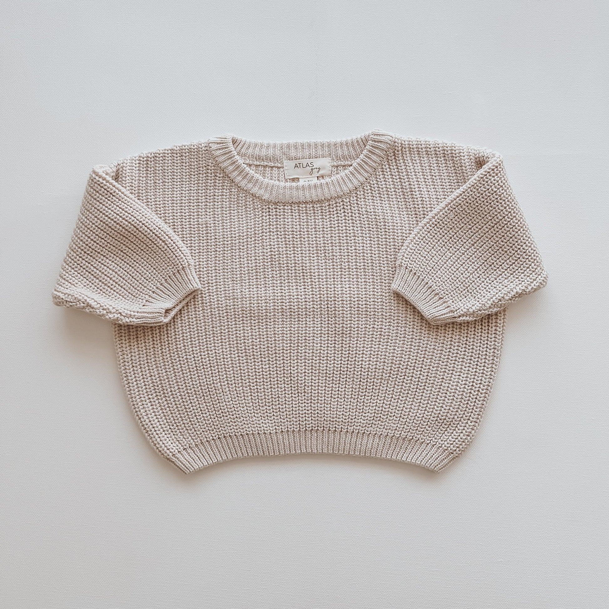 Beige knitted sweater on a light gray background