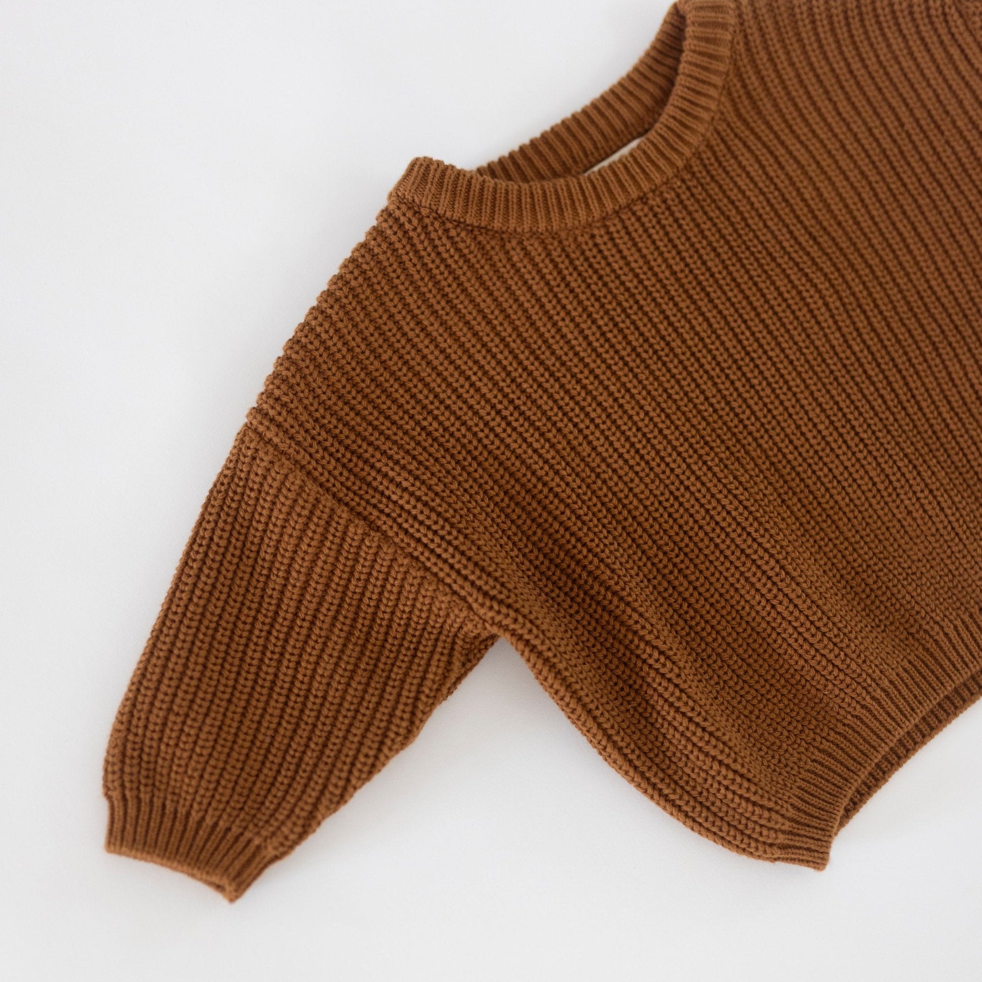 Brown knitted sweater sleeve on a white background