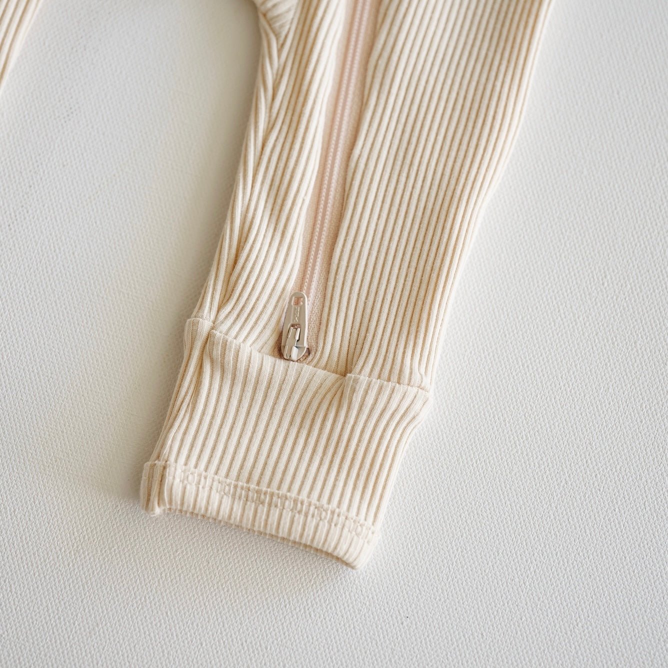 Beige ribbed tights with a zipper on a light gray background