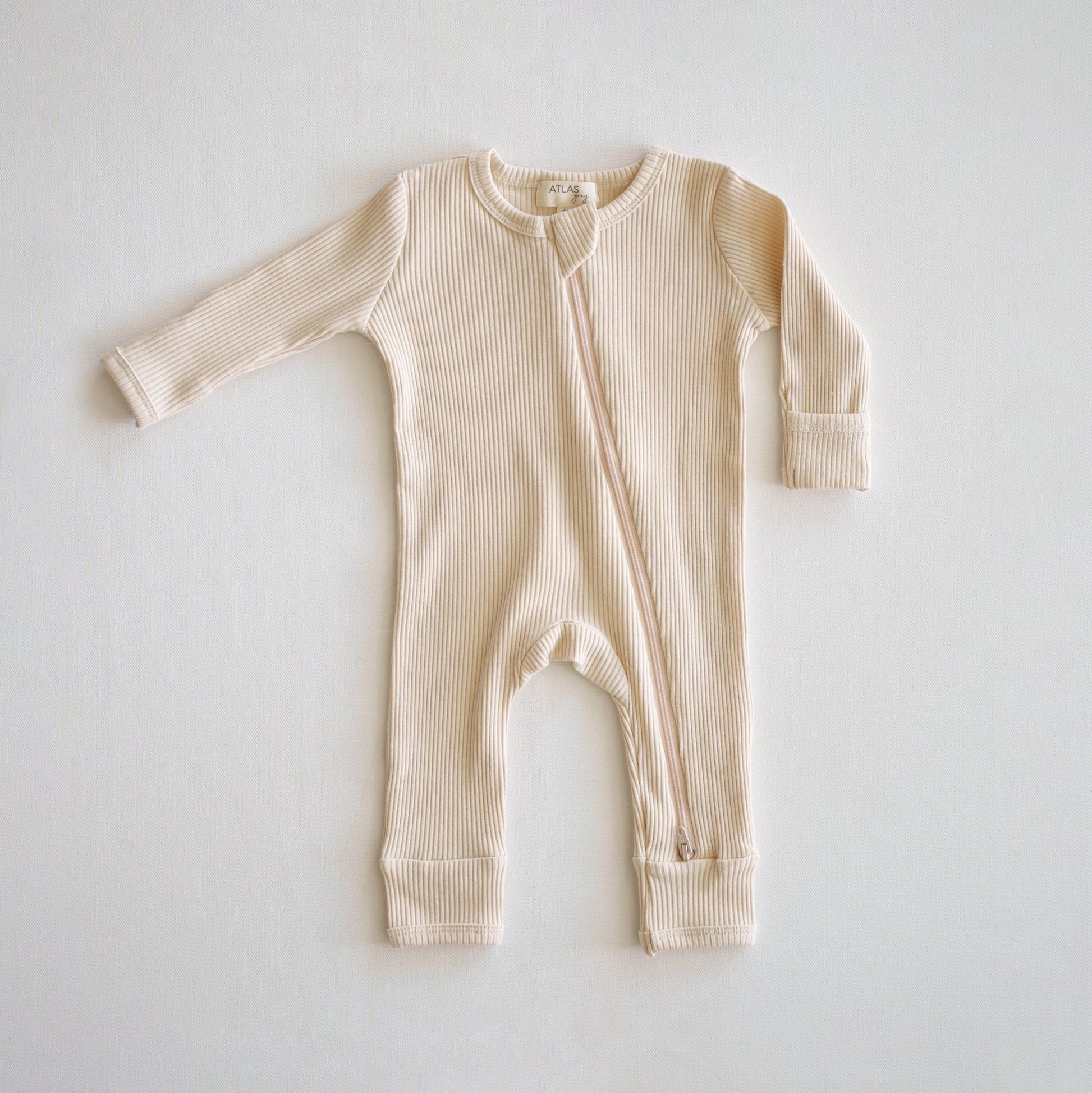 Beige baby onesie on a light gray background