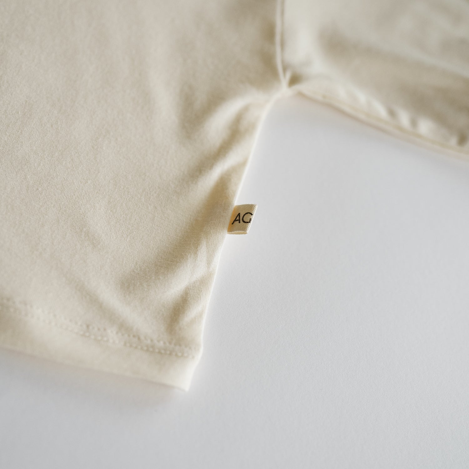 Close-up of a beige fabric with a brand tag on a white background