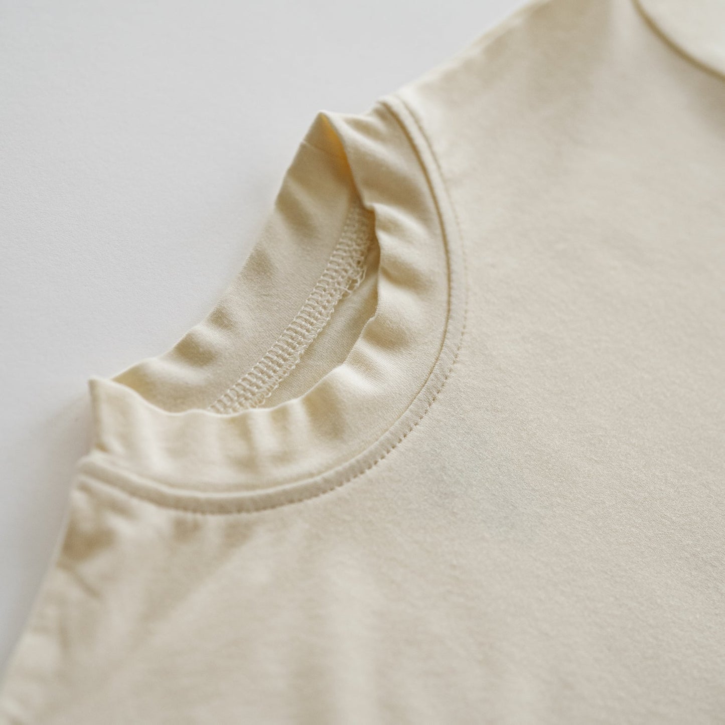 Close-up of a beige sleeveless top on a light gray background