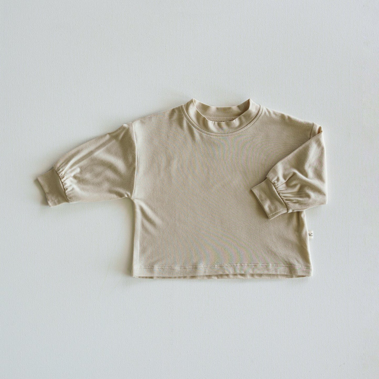Beige long-sleeve shirt on a light gray background