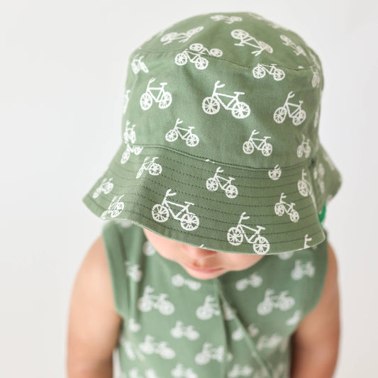 a baby wearing matching green bikes romper and sun hat