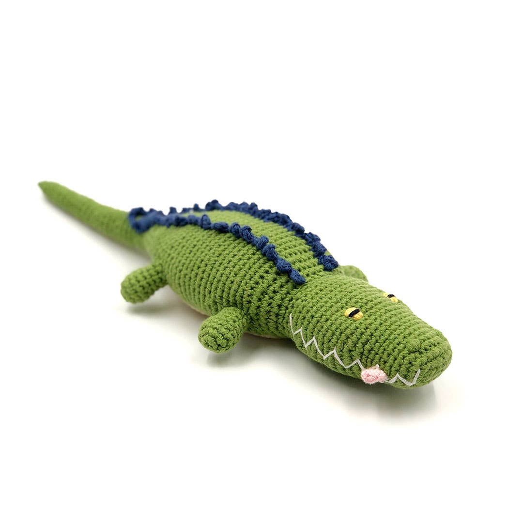 Green crocodile-shaped plush toy on a white background