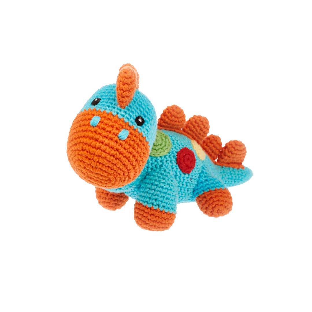 Crocheted dinosaur toy with teal body and orange back on a white background