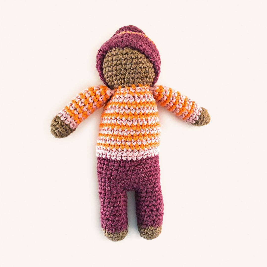 Knitted doll with a striped sweater and purple hat on a white background