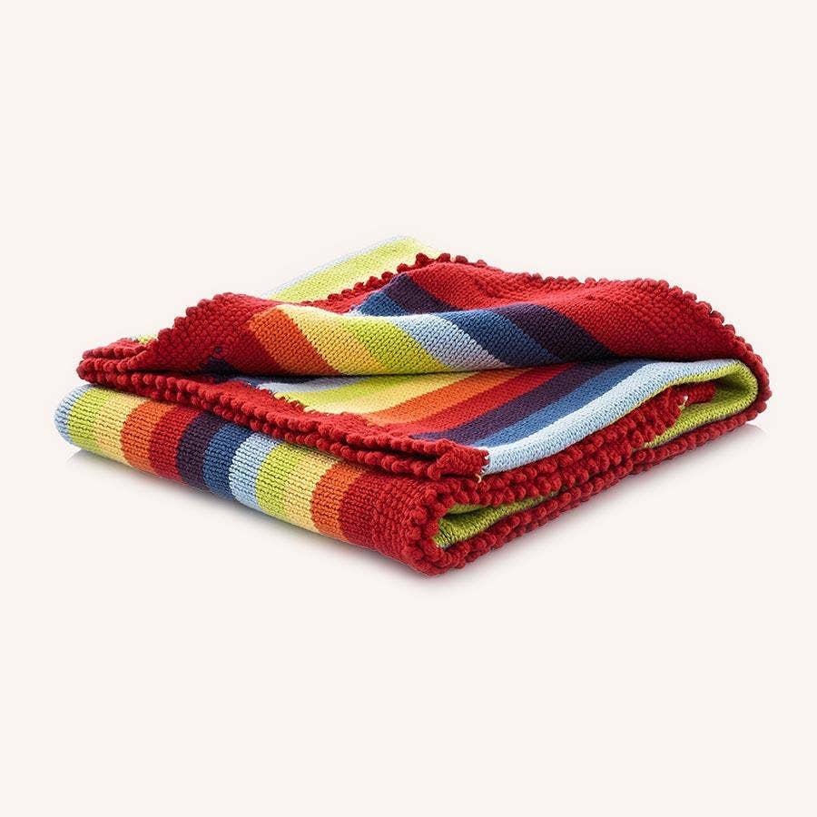 Rainbow striped blanket with red border on a white background
