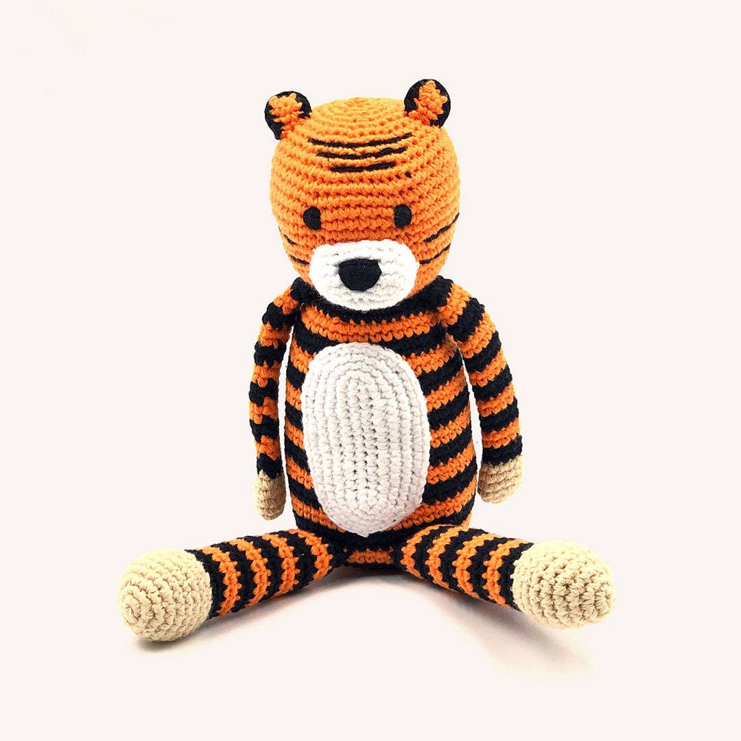 Crocheted tiger toy with orange, black, and white stripes on a white background