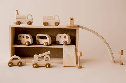 Wooden toy cars and a garage set on a beige background