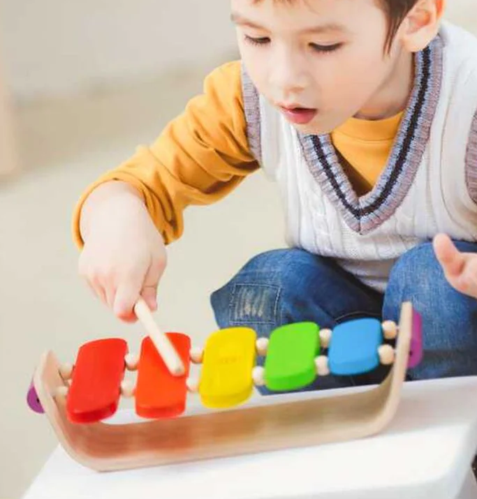 Child playing with the Oval Xylophone Rainbow 