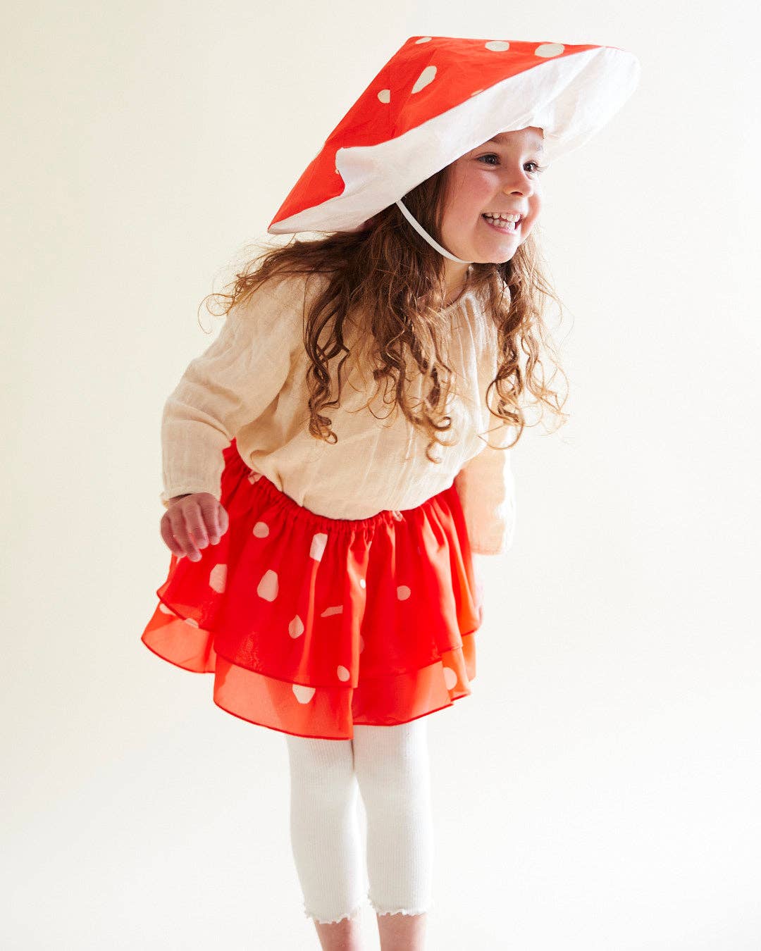 child wearing a silk mushroom costume with hat and tutu