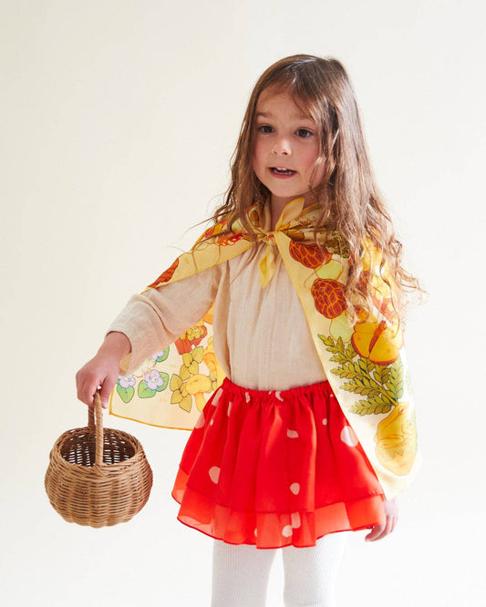 Child wearing a mushroom tutu and a mushroom playsilk as a cape