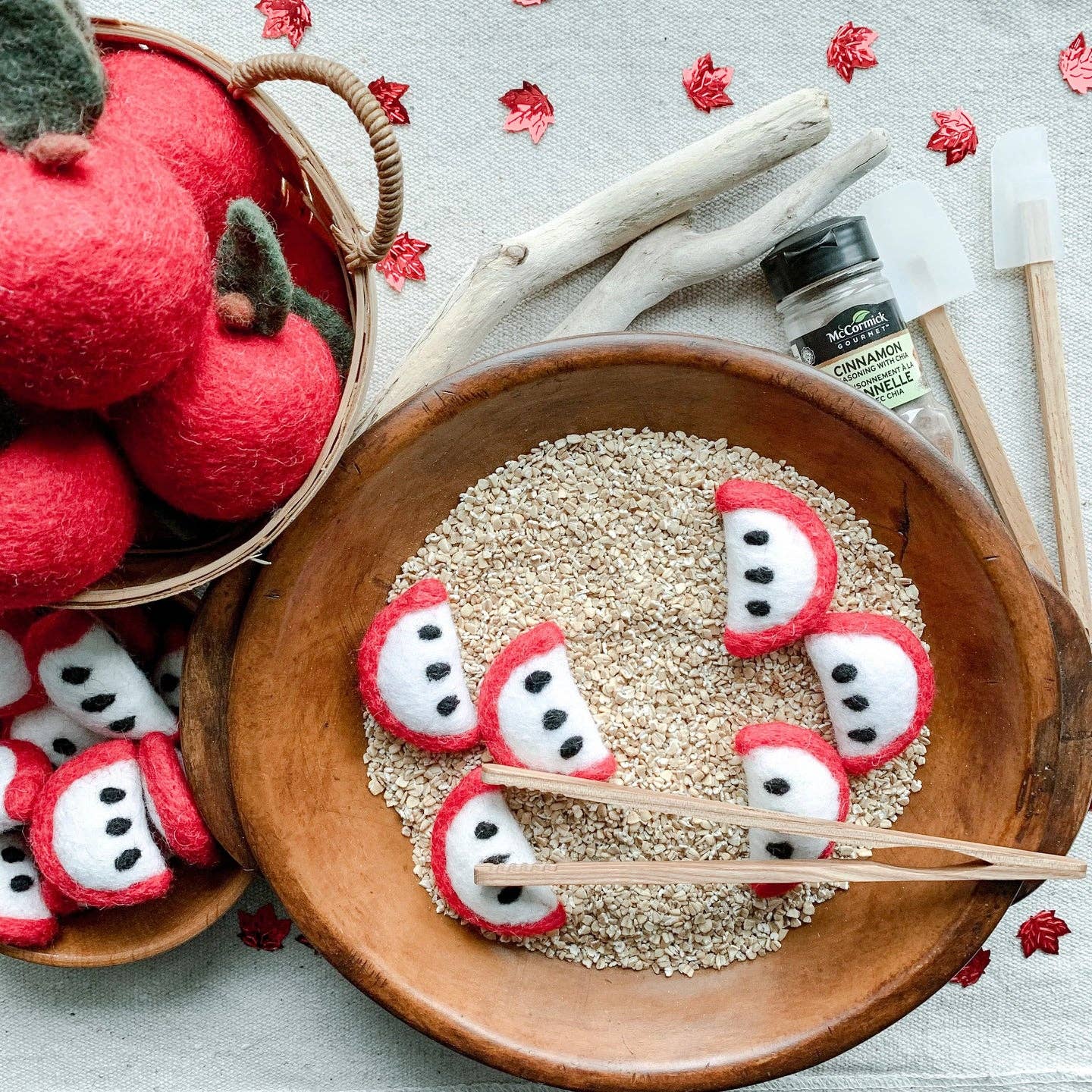 decor scene with wooden utensils and felt red apples