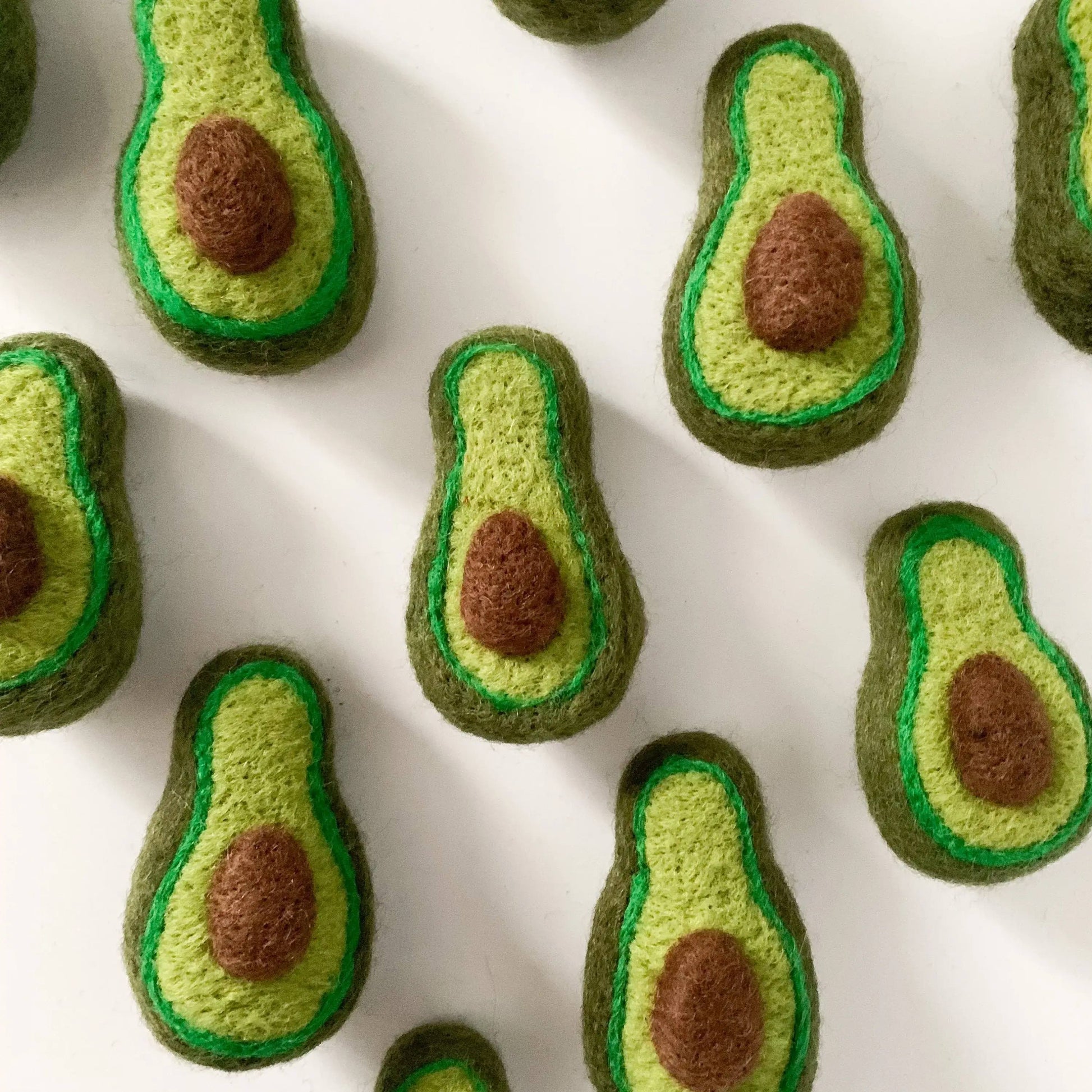 felt avocados on a white table