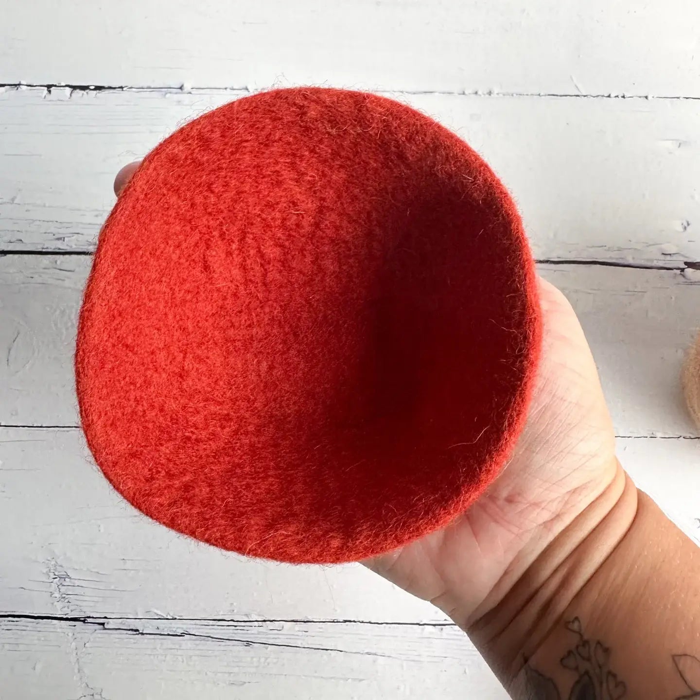 hand holding a red felt bowl