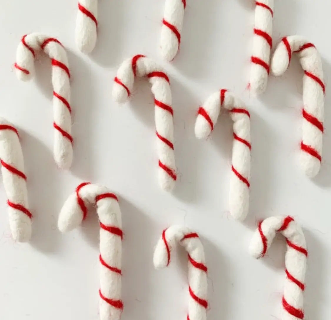 small felt candy canes on a white table