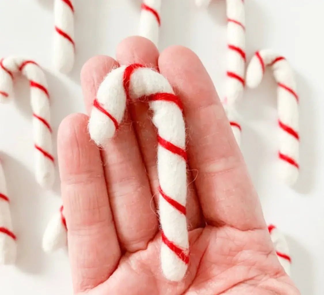 hand holding a felt candy cane