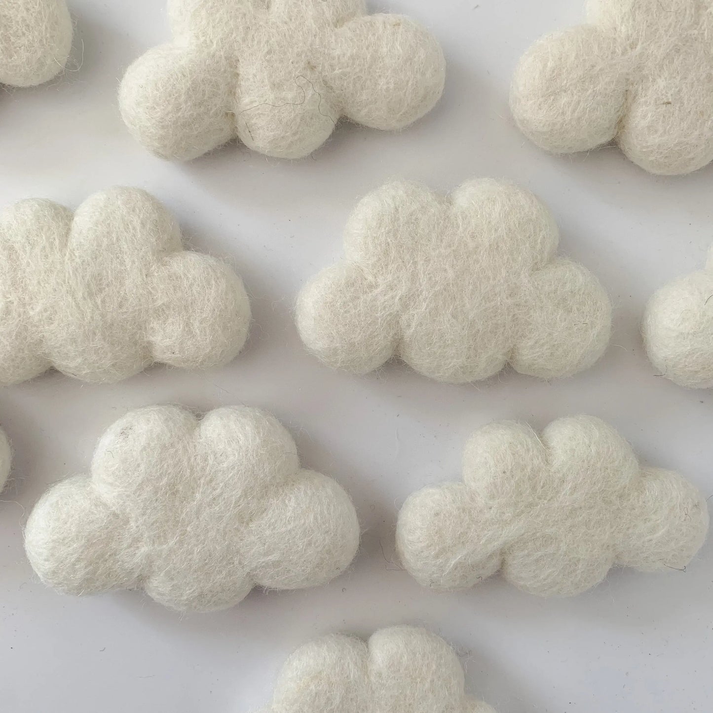 a bunch of felt white clouds on a white surface