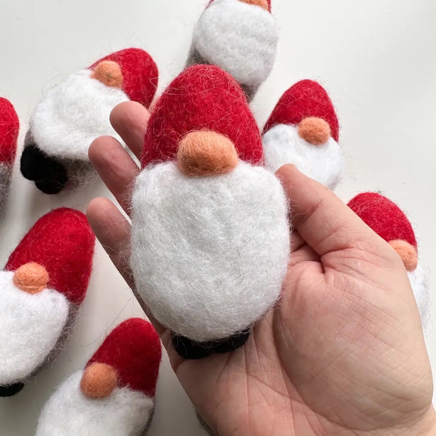 hand holding a felt gnome with a red hat