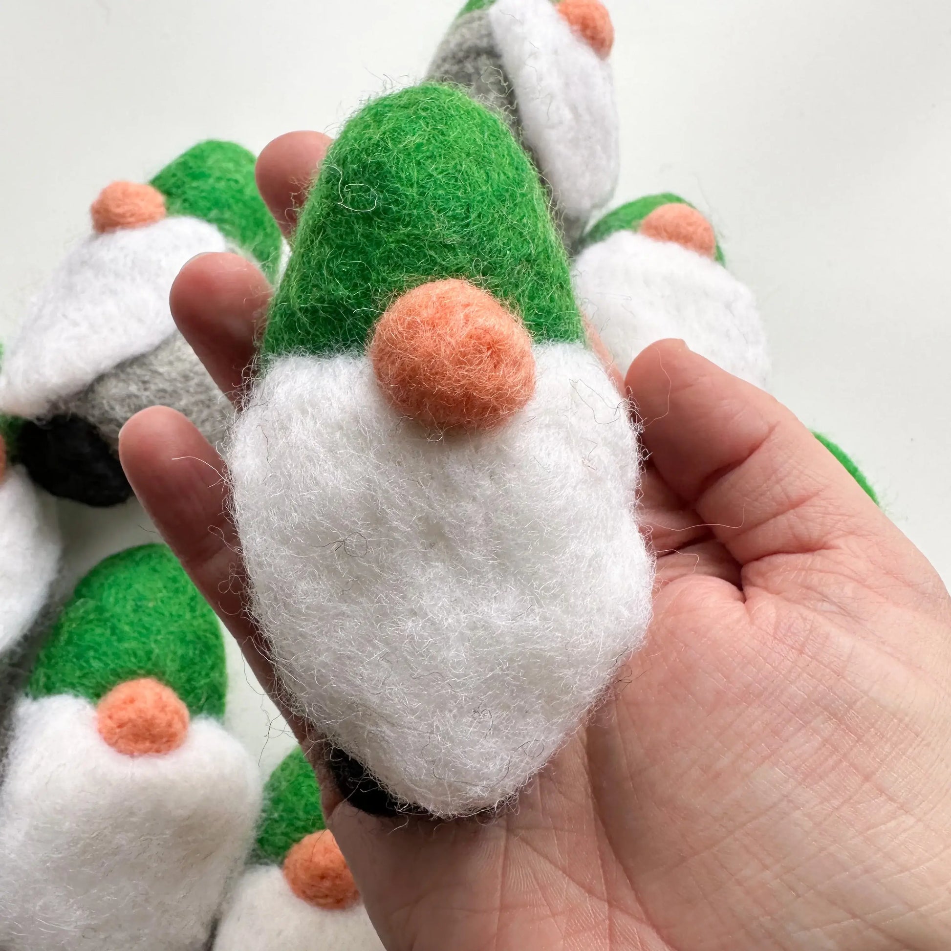 hand holding a felt gnome with a green hat