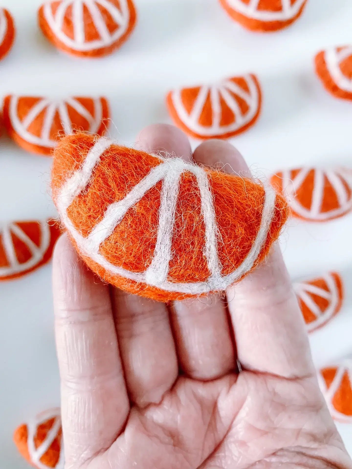 hand holding a felt orange slice