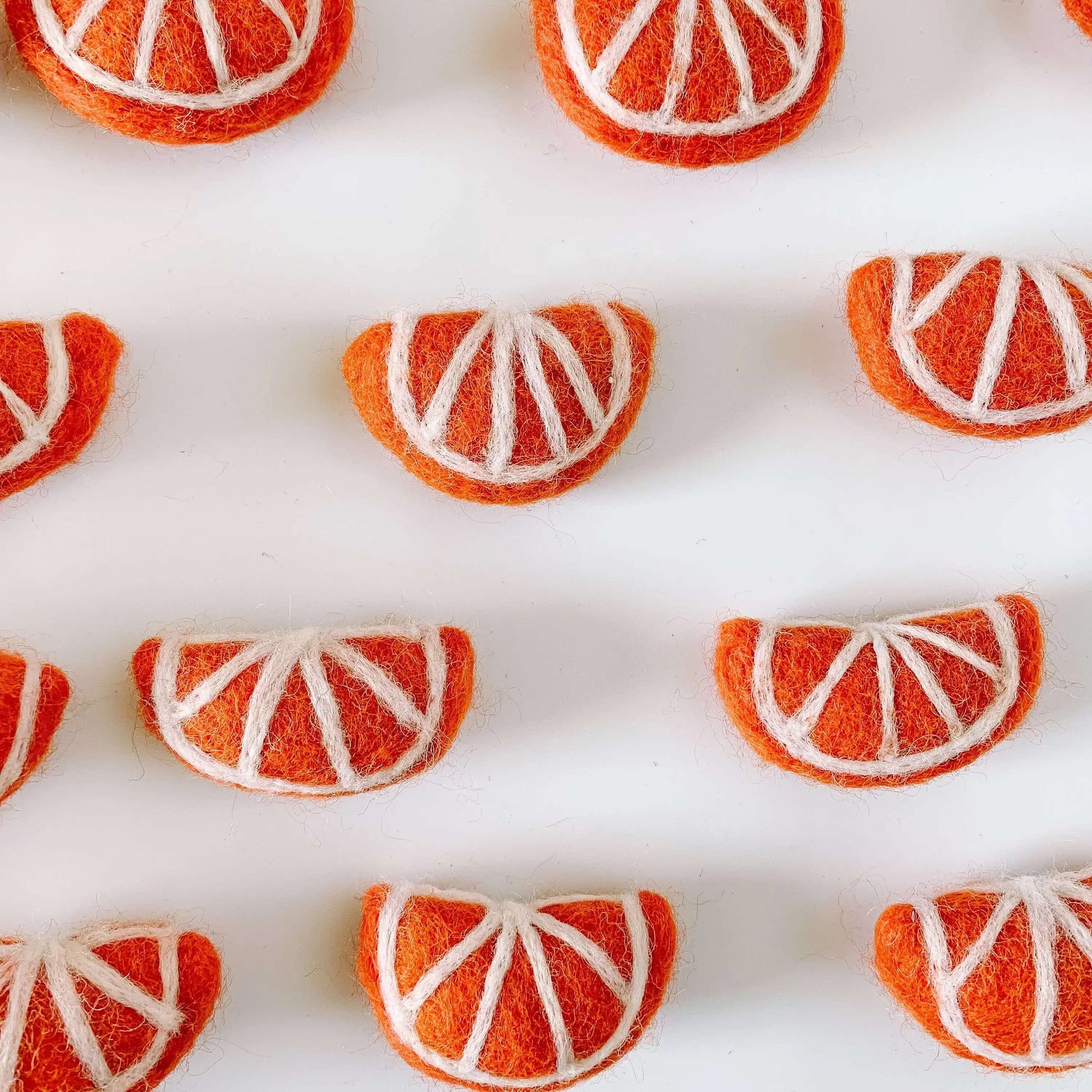 felt orange slices on a white table