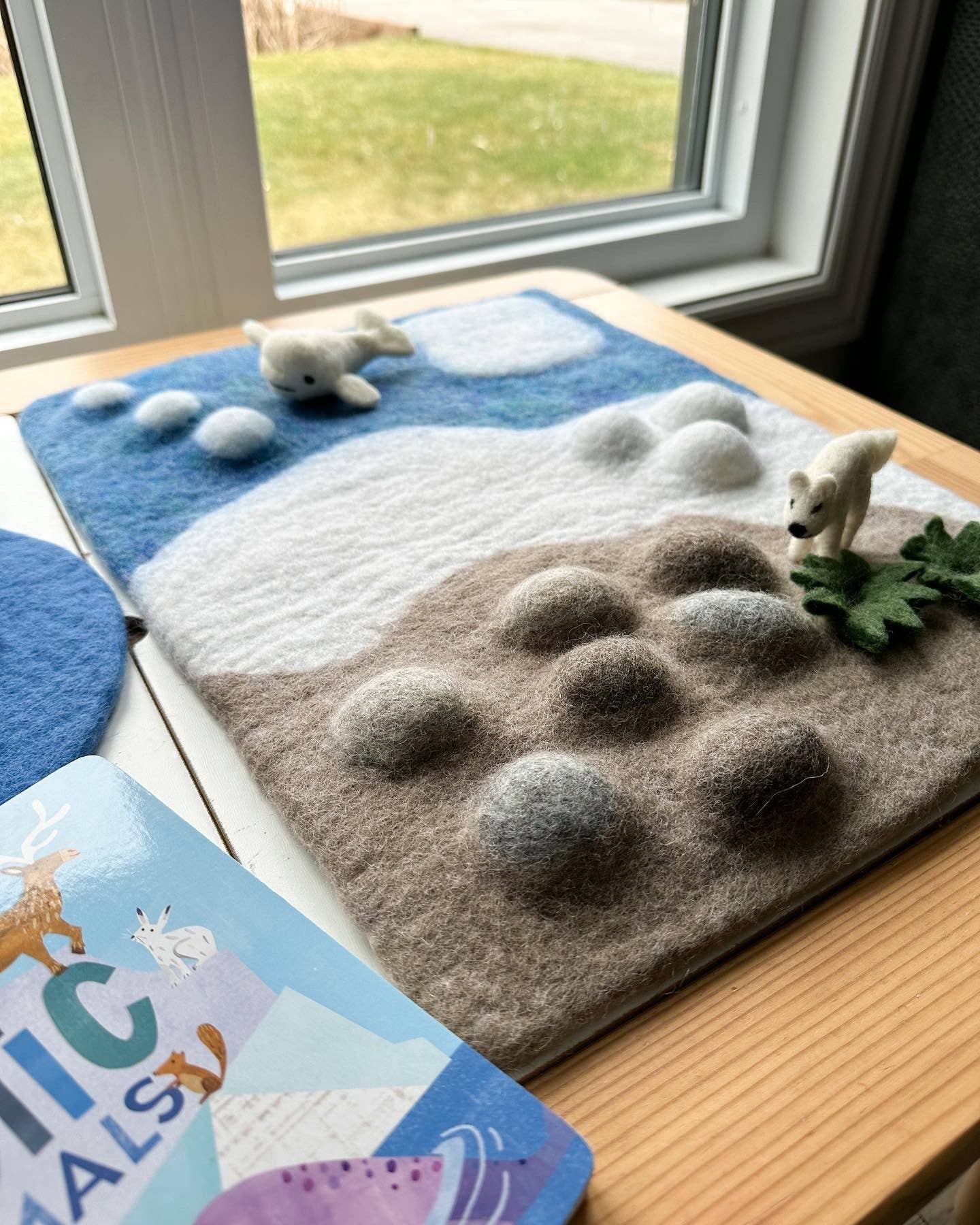 arctic tundra felt playmat by a window with fet polar bear