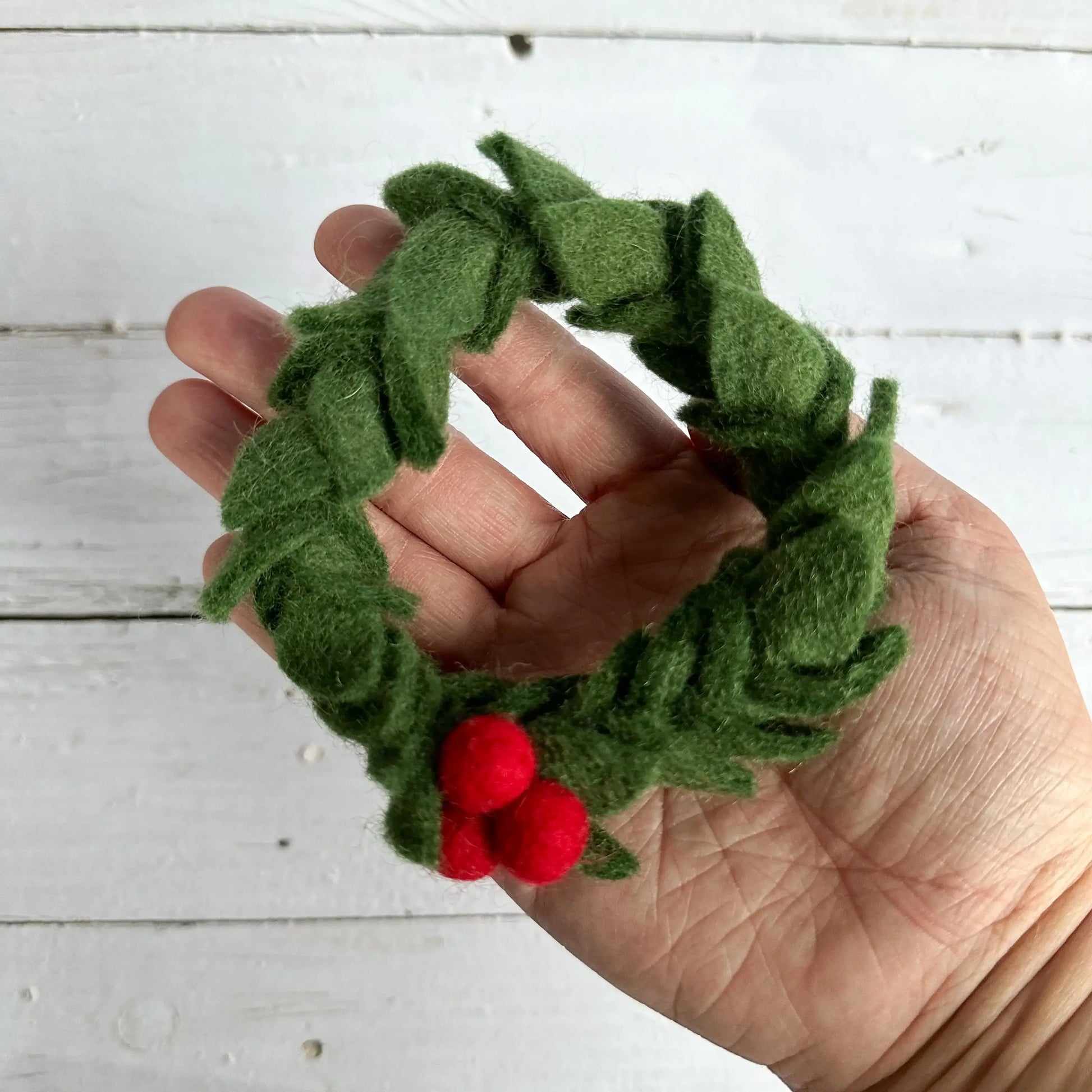 hand holding a mini felt christmas wreath