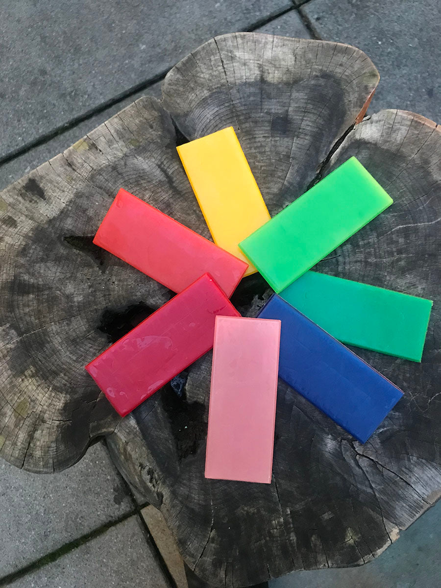 modeling wax sheets in assorted colors displayed in a star pattern on a wooden log