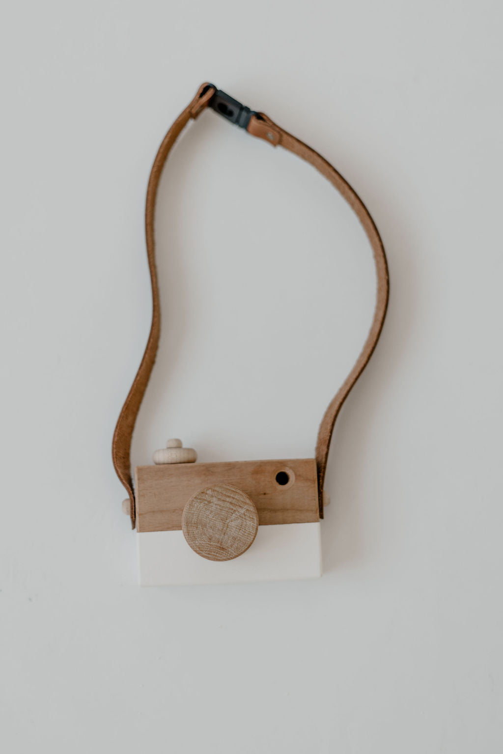 Wooden camera with leather strap on a white background