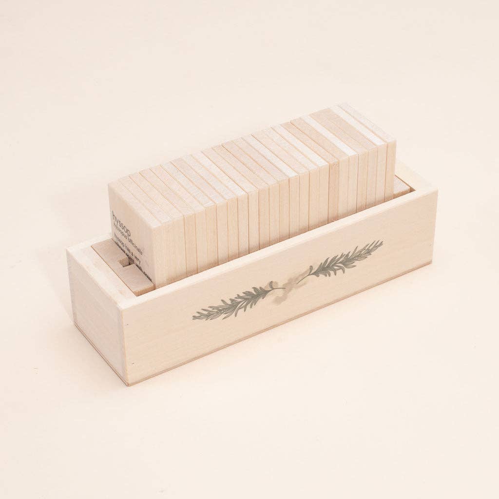 Set of white wooden tiles in a wooden box with a plant design on a light beige background