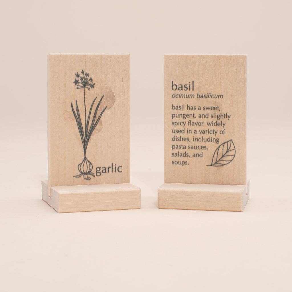 Two wooden ties with illustrations and text about garlic and basil on a beige background.