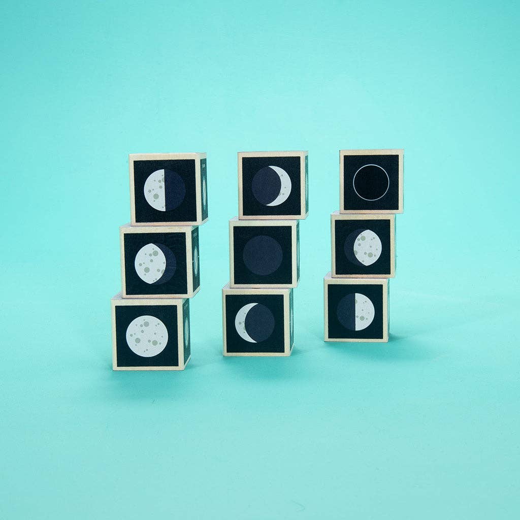 Wooden cubes with moon phases on a teal background