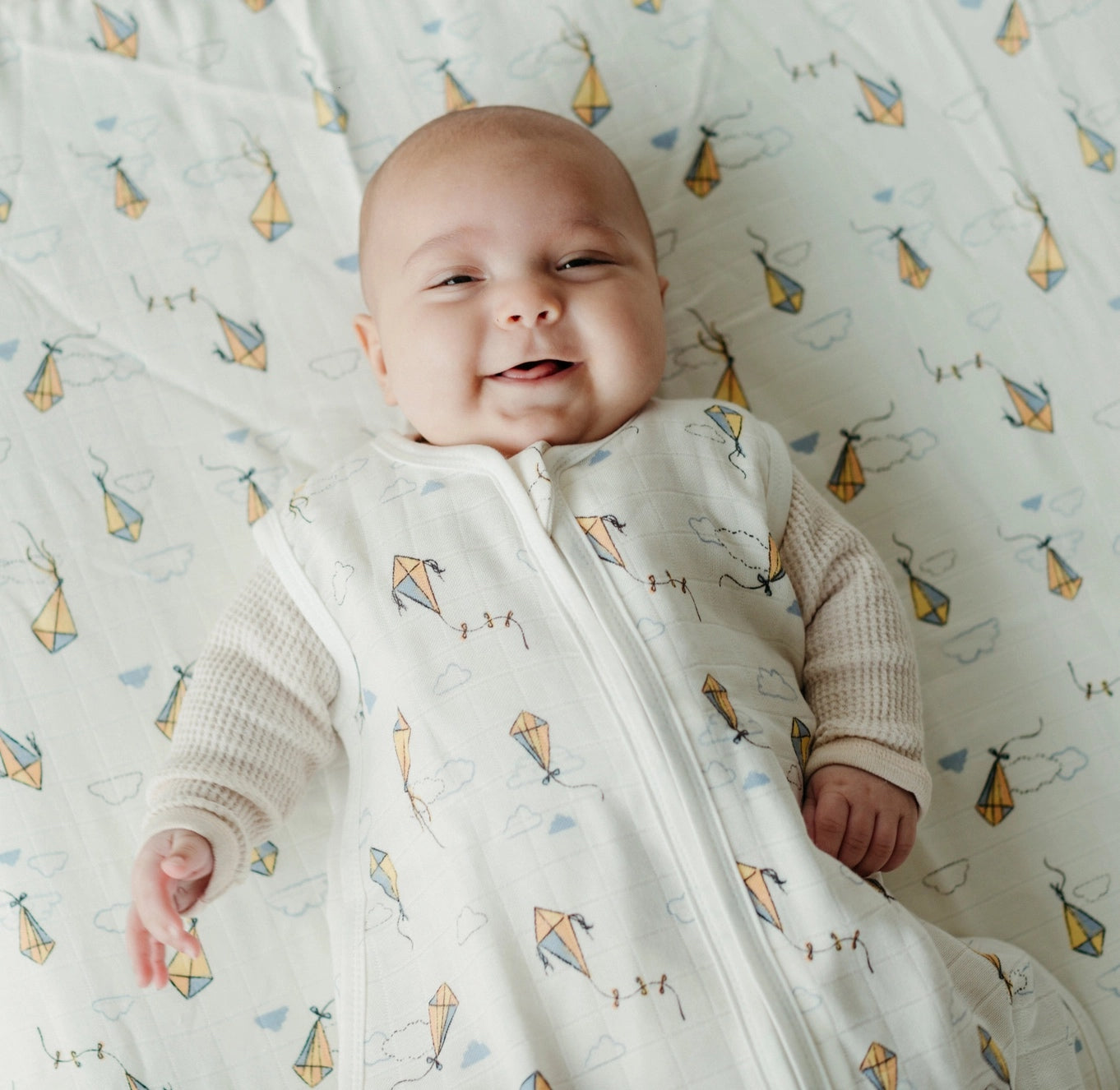 baby wearing organic muslin sleep sack in kites print