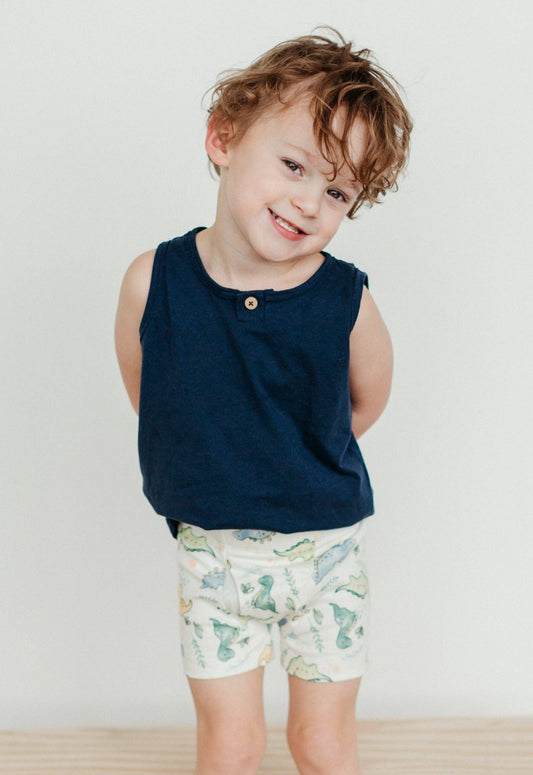 child wearing a blue tank top and dinosaur boxer briefs