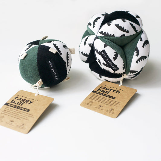 Two green and white patterned clutch balls with tags on a white background