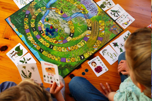 two children sitting on the floor playing wildcraft game about plants and herbs