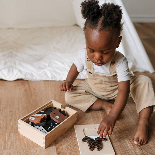 Child playing with wooden toys on a wooden floor