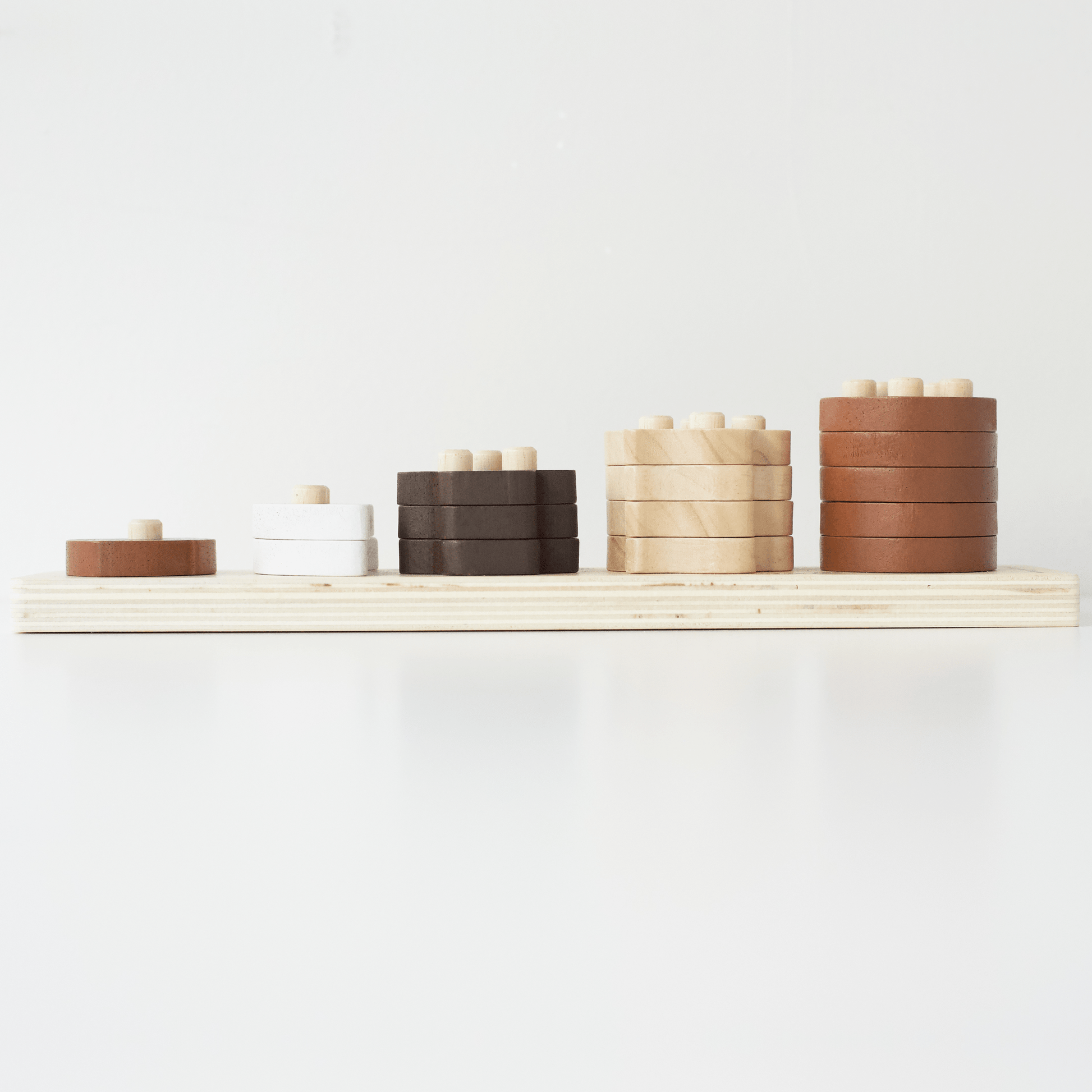 Set of wooden cylindrical containers stacked on a wooden shelf against a white background
