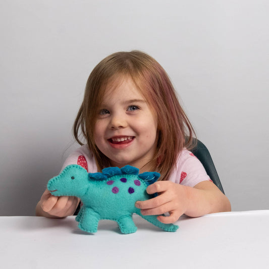 child playing with felt blue baby dinosaur