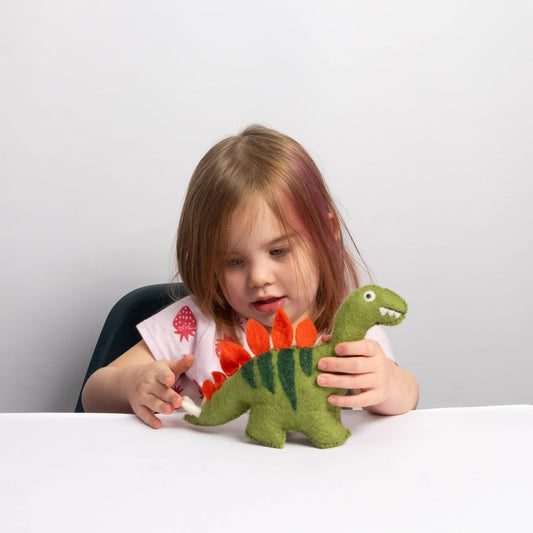 child playing with a wool felt stegosaurus