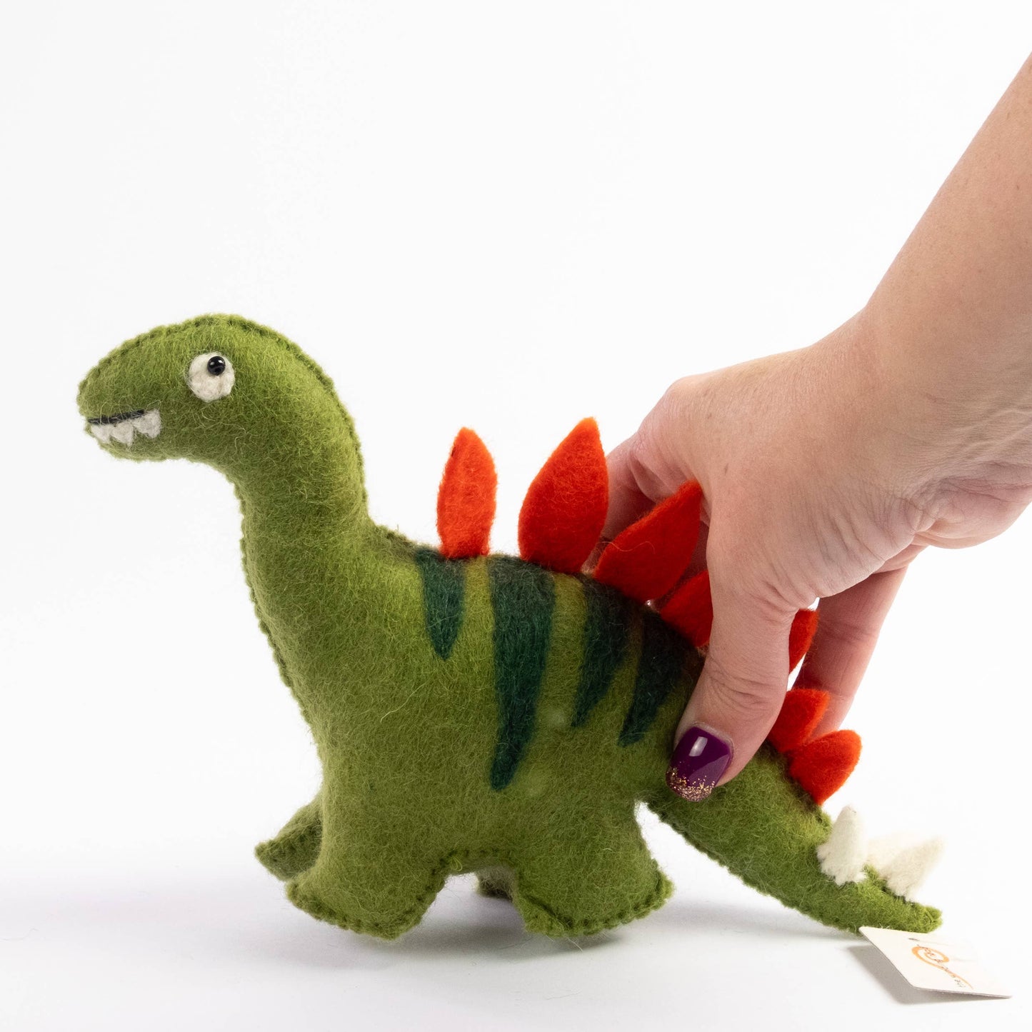 hand holding a wool felt stegosaurus