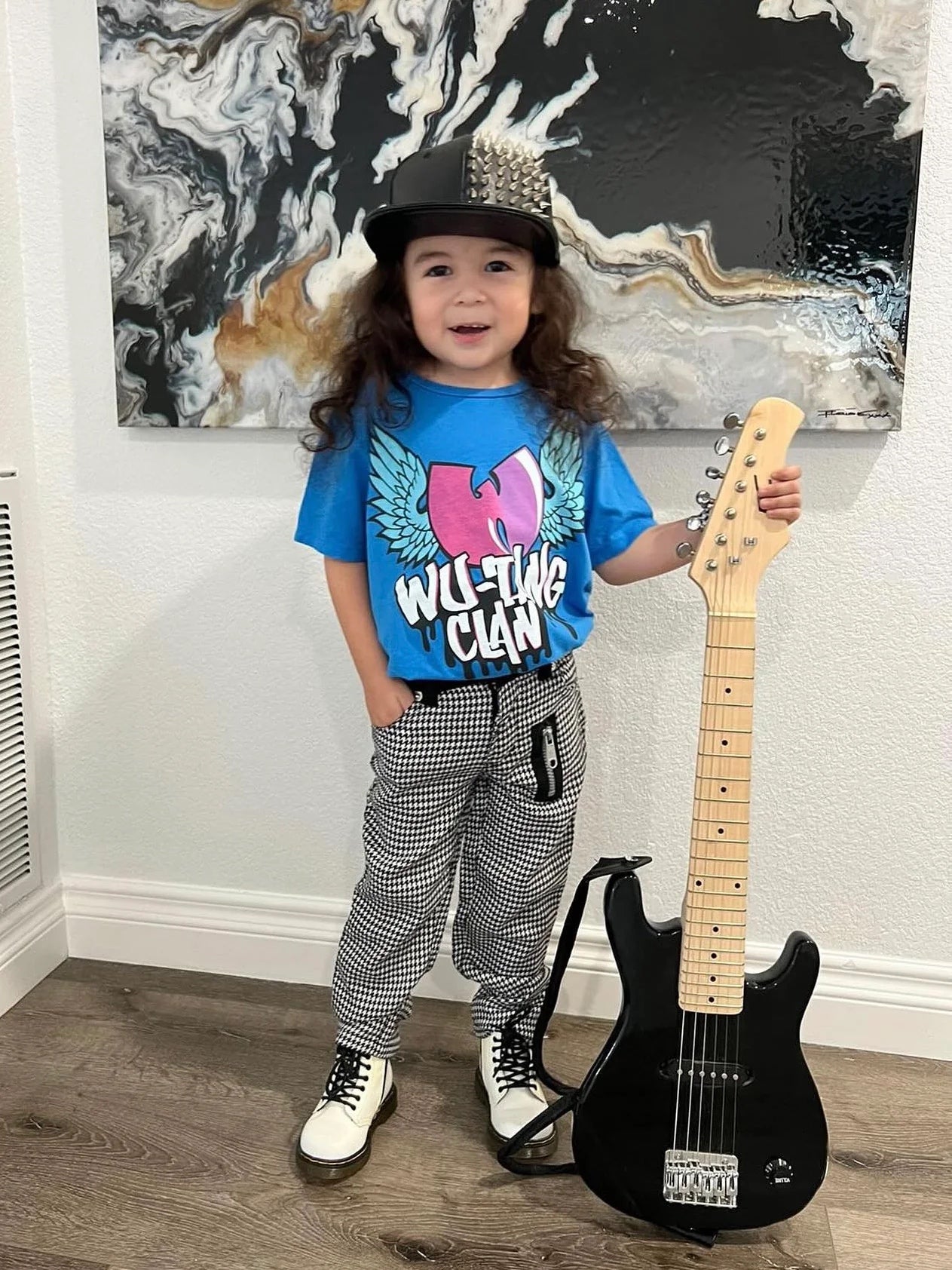 Child wearing Wu-Tang Clan blue organic short sleeve tee and holding an electric guitar