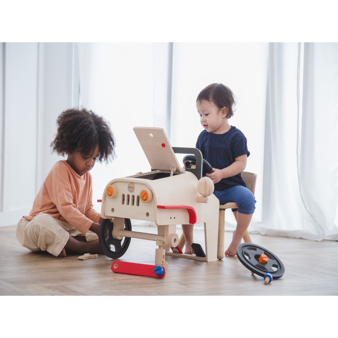 Kids playing with the Motor Mechanic by Plan Toys