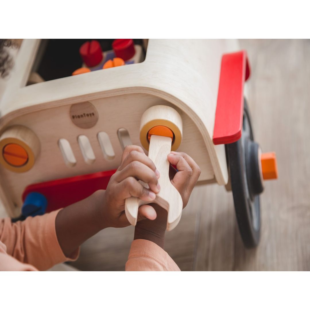 child playing with the Motor Mechanic by Plan Toys