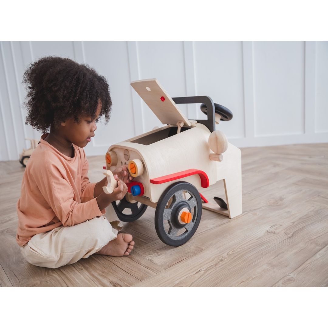 Kid playing with the Motor Mechanic by Plan Toys