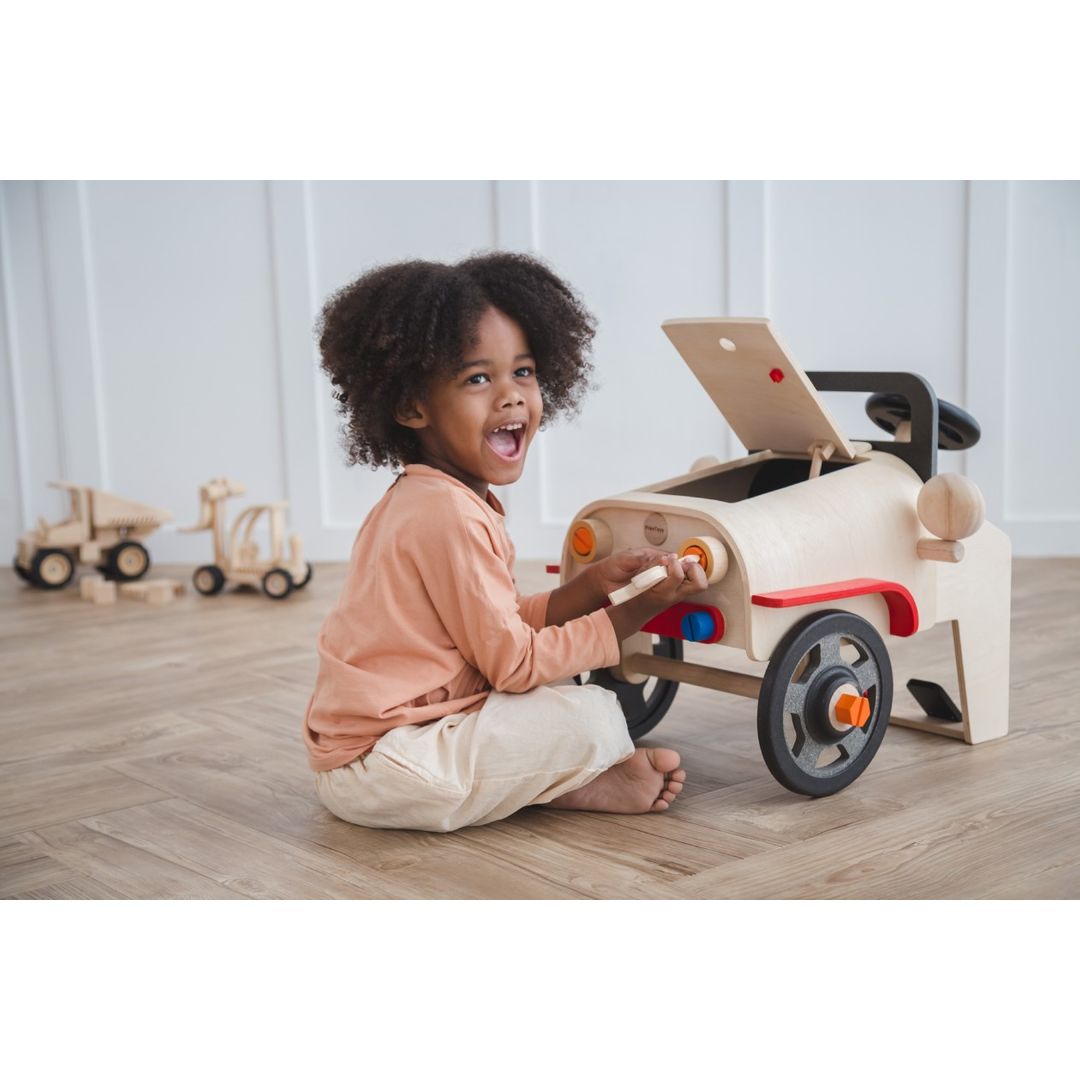 Kid playing with the Motor Mechanic by Plan Toys