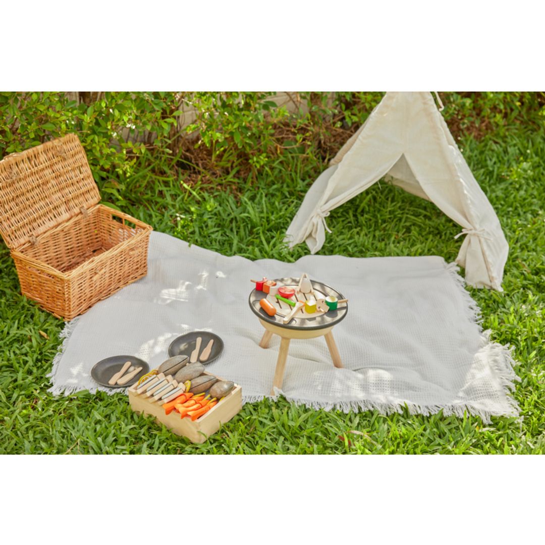 BBQ Playset by Plan Toys on a blanket with a kids size tent