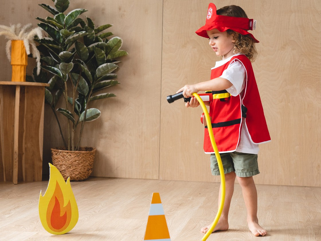 child playing with the Fire Fighter Play Set by Plan Toys
